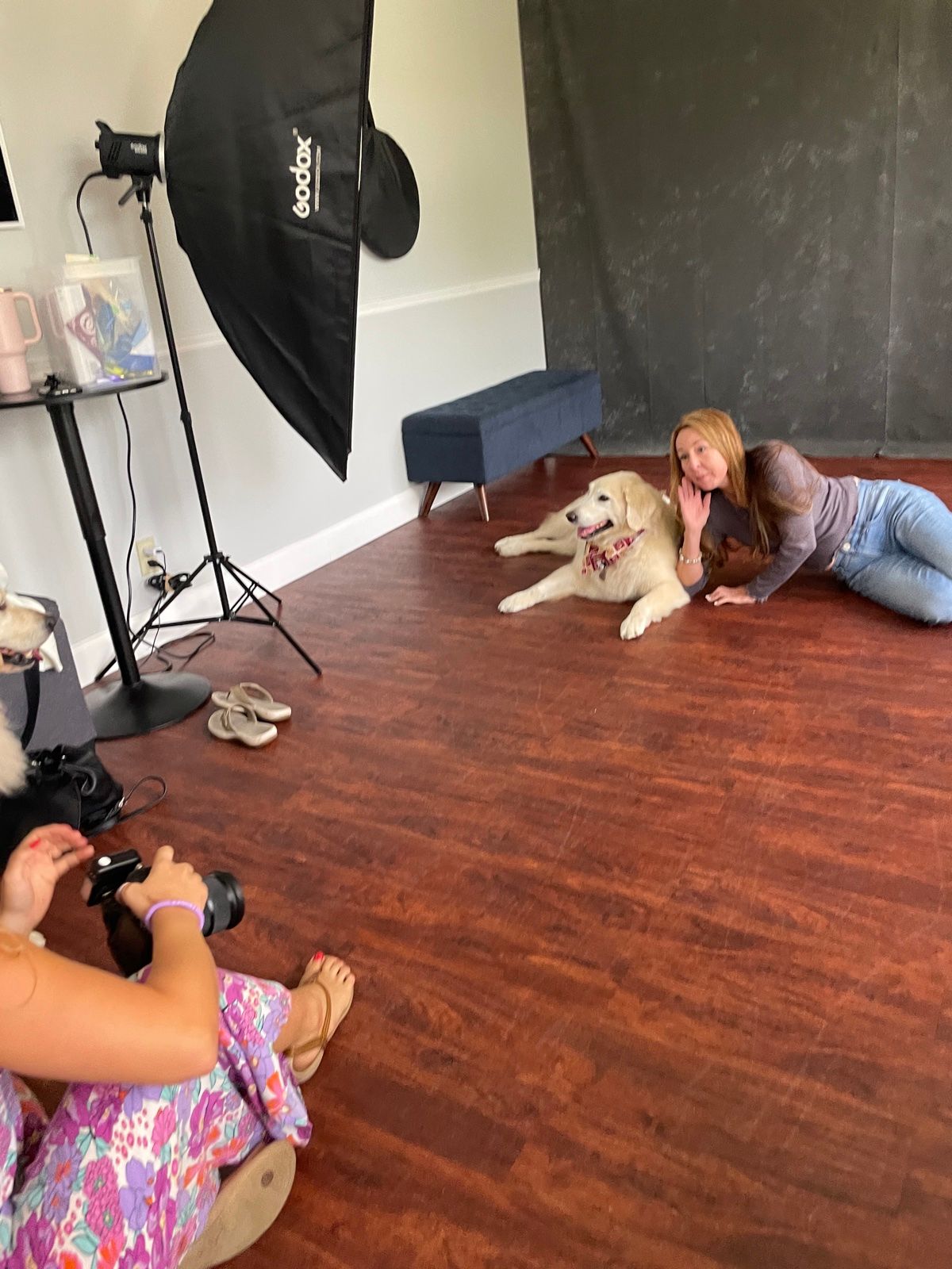 Inside the Boca Raton studio: a client lies on the floor with her white dog while the photographer works