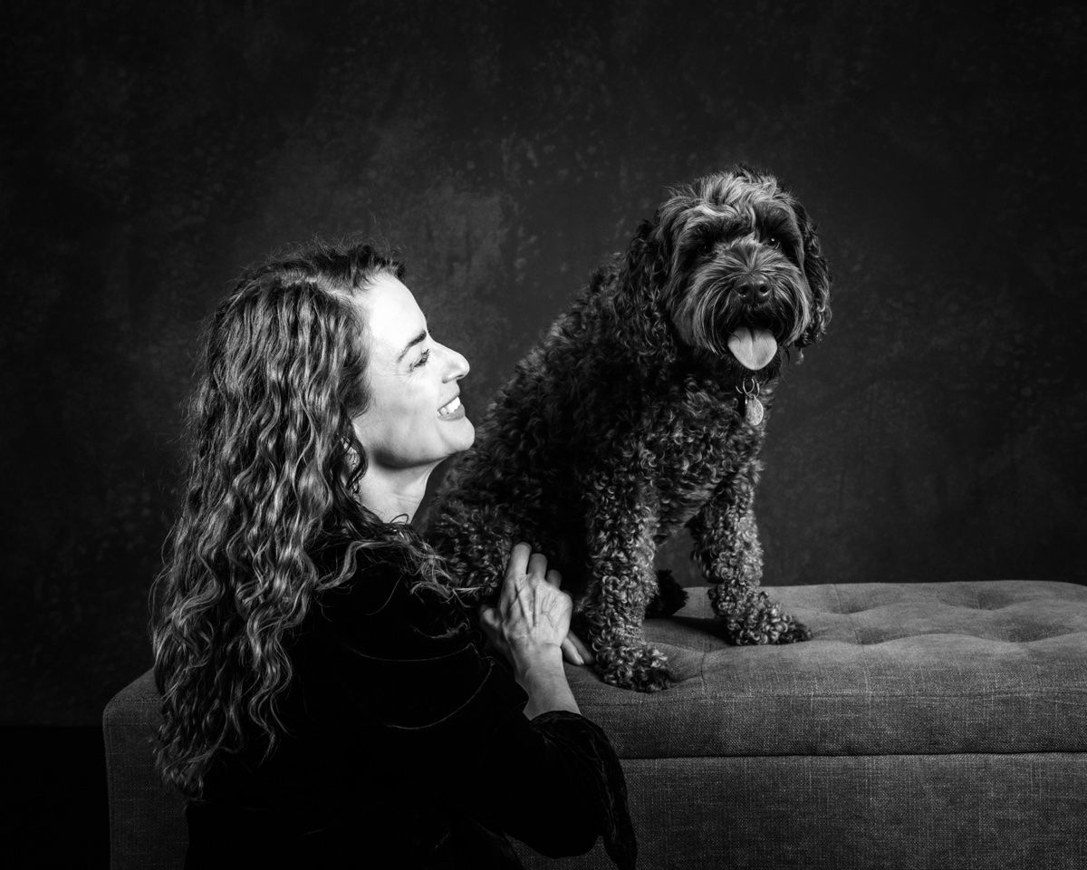 Jonna and her black doodle on the studio bench