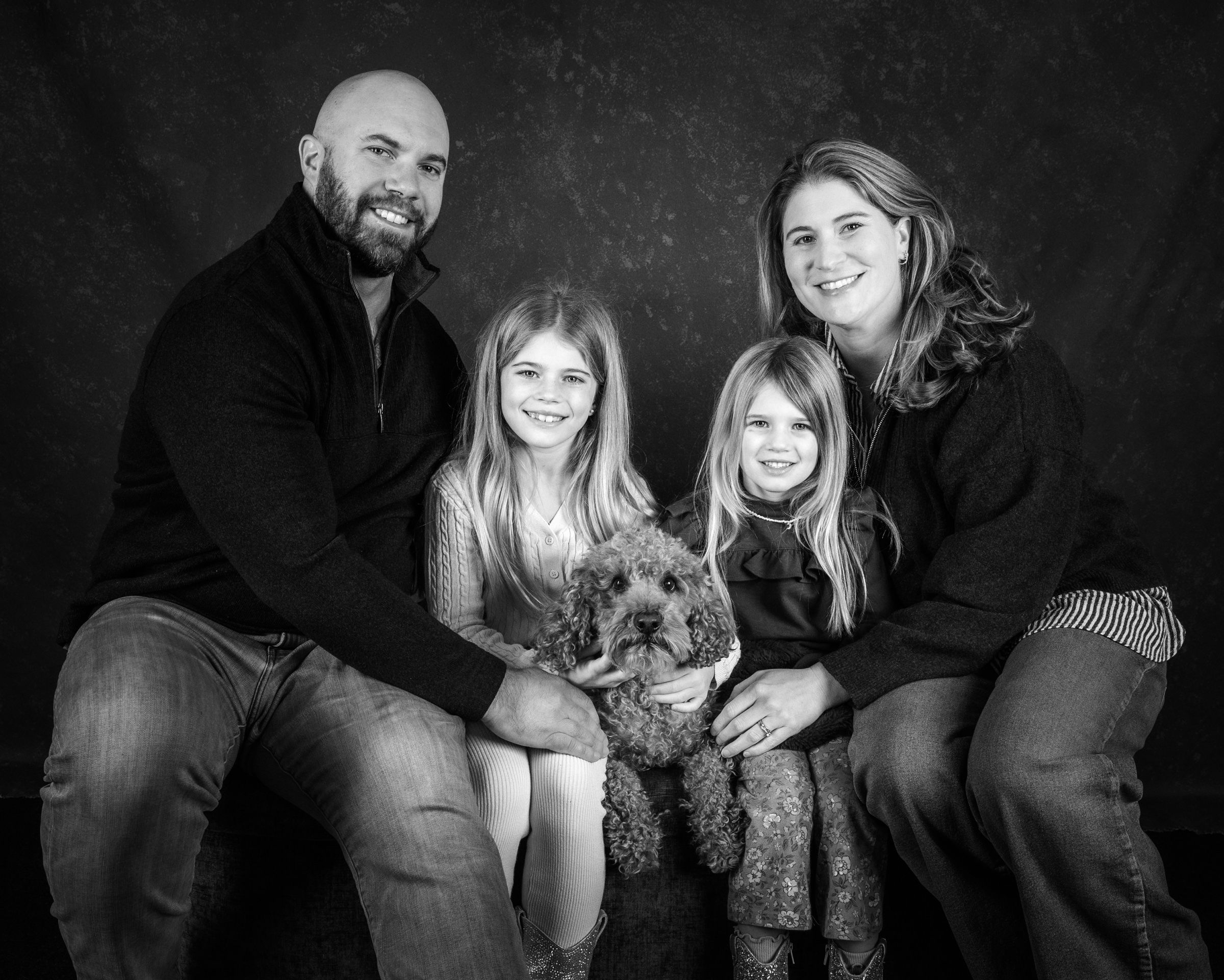A family of four on the studio bench with their doodle