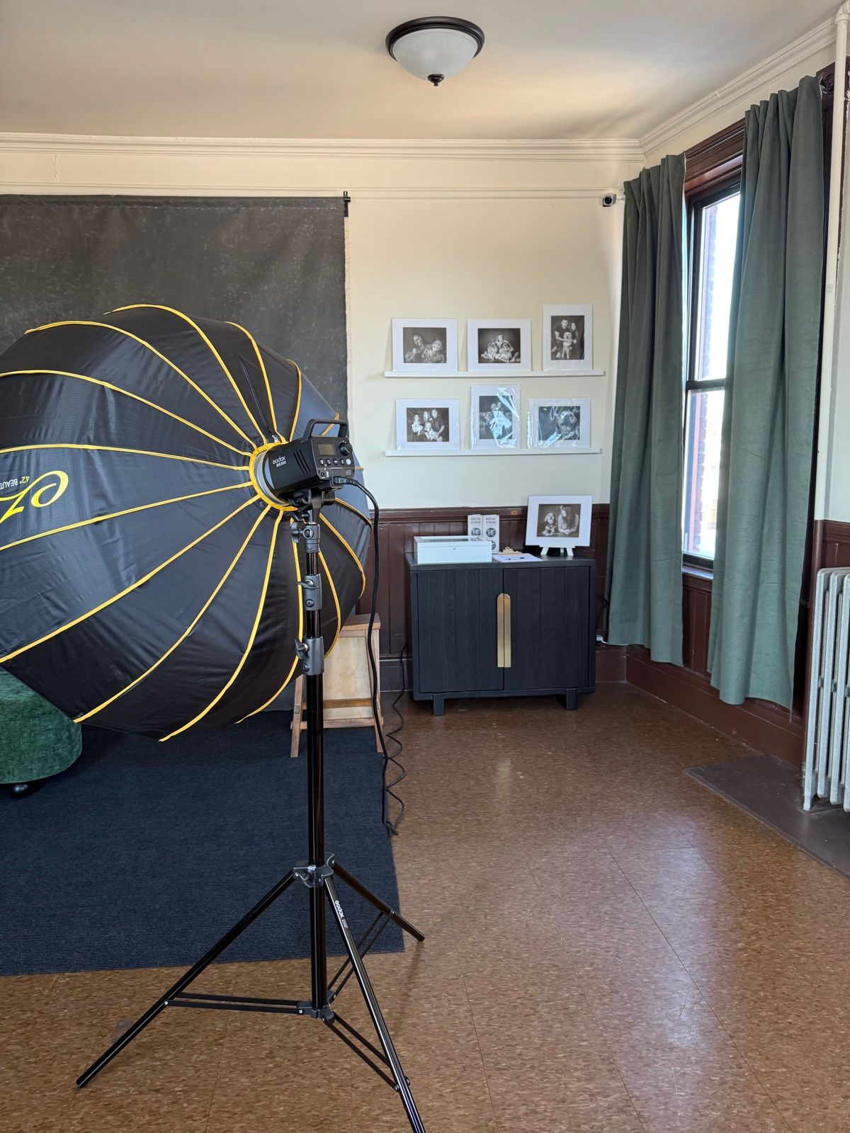 The Natick studio: the backdrop, a light and framed portraits on the wall