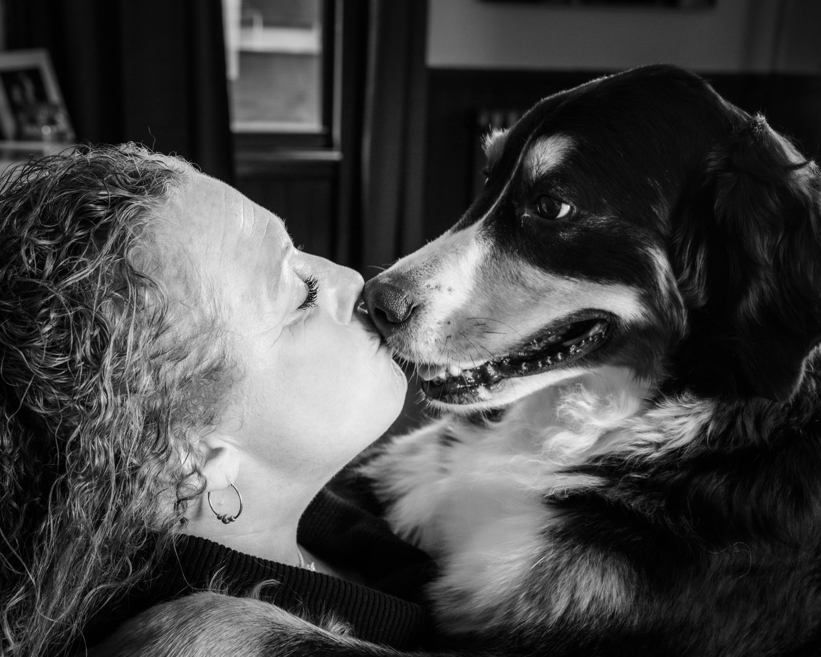 A woman and her tricolor dog nose to nose