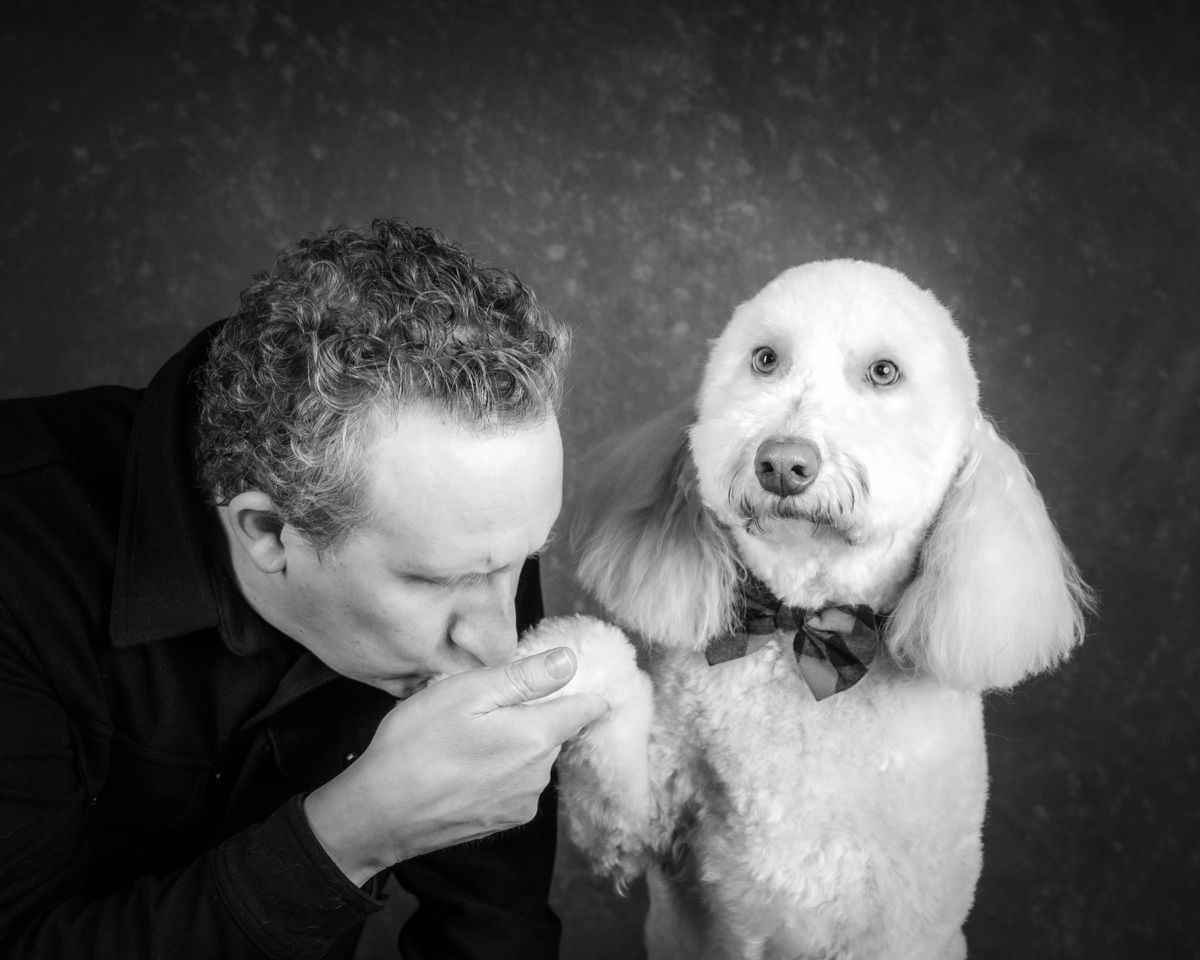 The husband kissing the poodle's paw