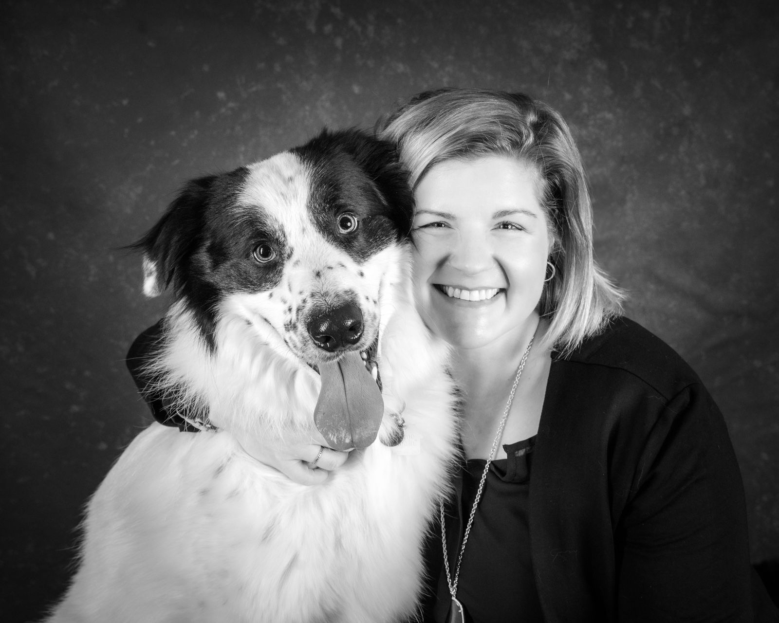 A woman cheek to cheek with her border collie