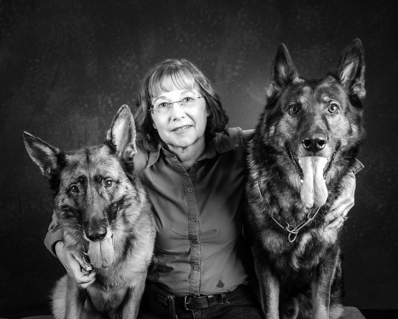 A woman between her two German shepherds